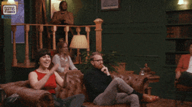 a group of people sitting on a couch with a game changer logo