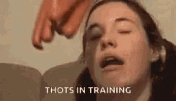 a woman is sitting on a couch with her eyes closed and a sausage being thrown at her face .