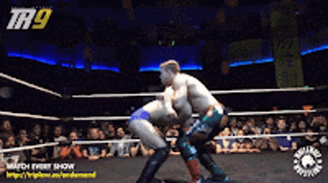 two men are wrestling in a ring with the number 9 on the top