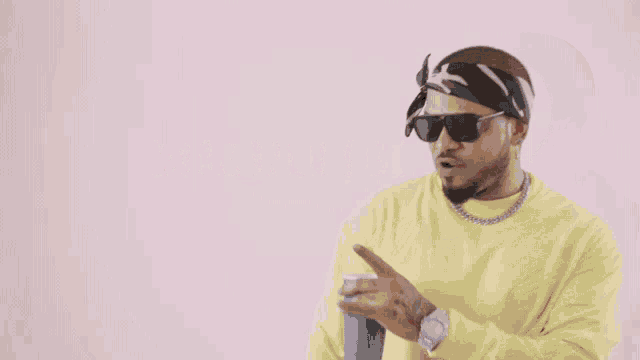 a man wearing sunglasses and a bandana holds a blue cup in front of the word malianted