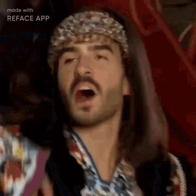 a man with long hair and a beard is wearing a headband and singing into a microphone .