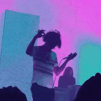a man is singing into a microphone while dancing on a stage .