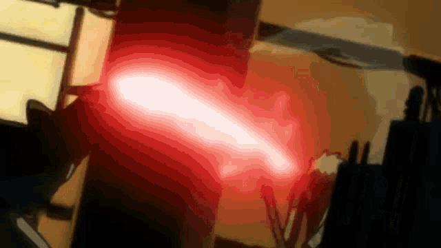 a red light beam is coming out of a person 's hand
