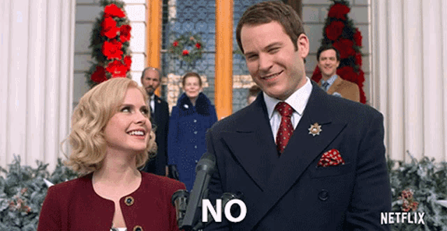 a man and a woman are standing in front of a microphone with the word no on their faces