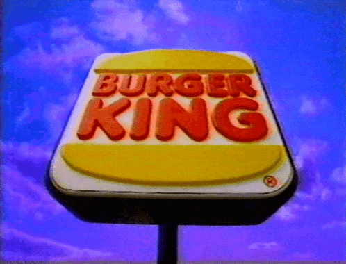 a sign for burger king against a blue sky
