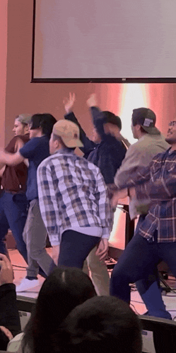 a group of people are dancing in front of a screen that says ' projector ' on it
