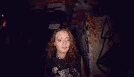 a woman is standing in a hallway with her arms outstretched and looking at the camera .