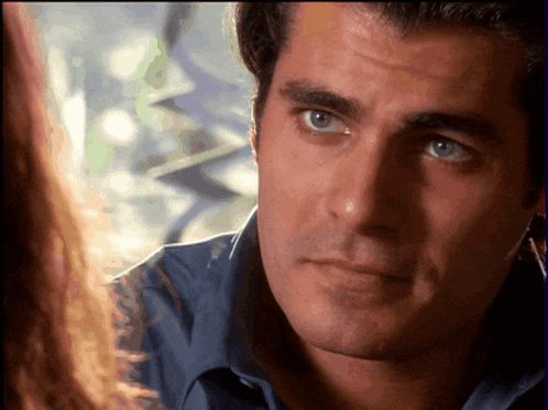 a man in a blue shirt is looking at a woman