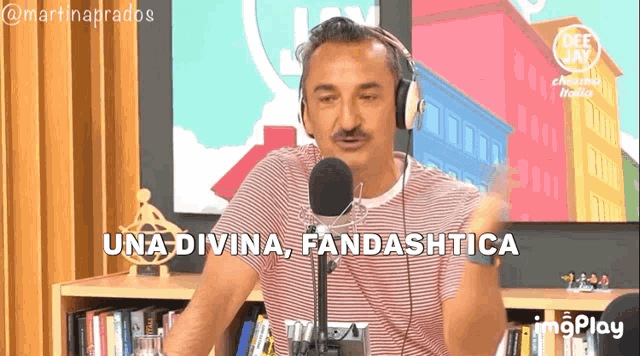 a man wearing headphones stands in front of a microphone and says una divina