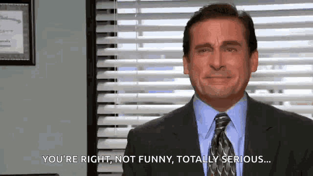 a man in a suit and tie is making a funny face in front of a window .