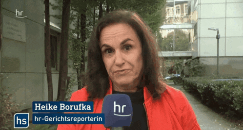 a woman wearing a red jacket and a microphone with the name heike borufka