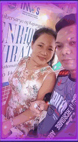 a man and a woman are posing for a picture in front of a sign that says ims