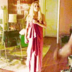 a woman in a red dress is wrapped in a towel in a living room