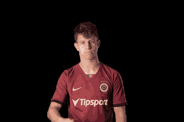 a man wearing a red shirt that says tipsport