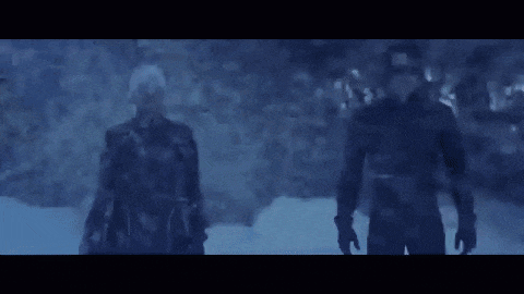 a couple of men standing next to each other in the snow in the dark .