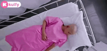 a man with a bald head is laying in a hospital bed .