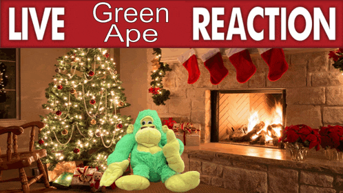 a green stuffed monkey sits in front of a christmas tree