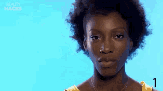 a woman with curly hair is looking at the camera .