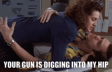 a woman laying on top of a man with the words your gun is digging into my hip