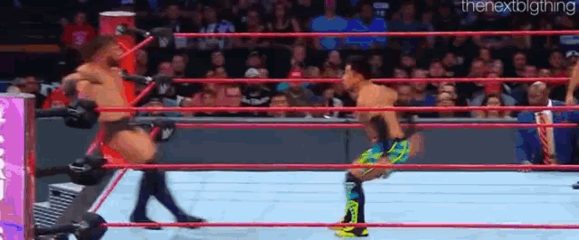 two men are wrestling in a wrestling ring .
