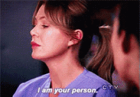 a woman in scrubs says i am your person in front of a man