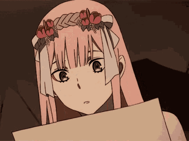 a girl with pink hair and flowers in her hair is holding a piece of paper