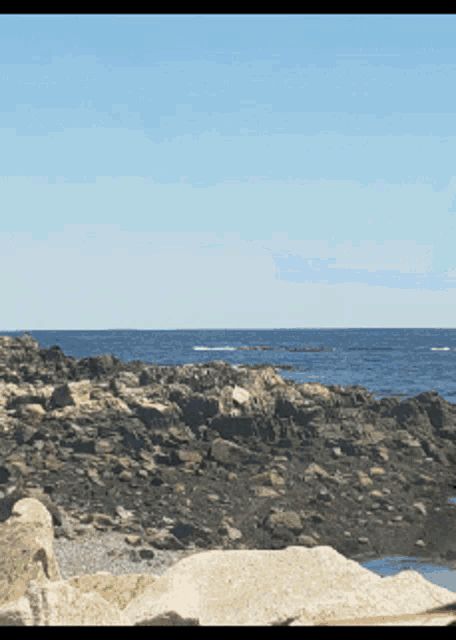 a view of the ocean from a rocky shoreline