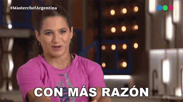 a woman in a pink shirt says con mas razon in white letters