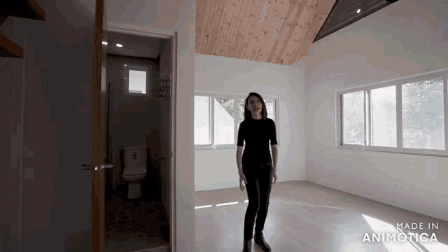 a woman is standing in an empty room with the words made in animotica on the bottom