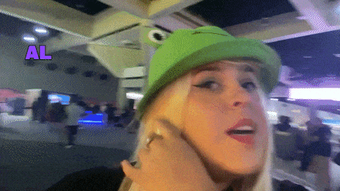 a woman wearing a green hat with a frog on it and the word al above her