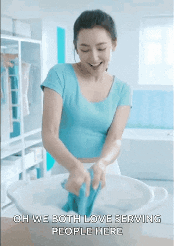 a woman in a blue shirt is washing clothes in a bowl with the words oh we both love serving people here