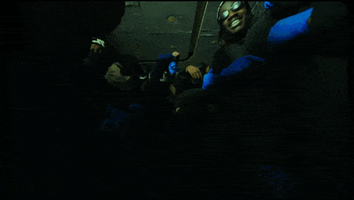 a group of people wearing blue gloves are posing for a picture in a dark room