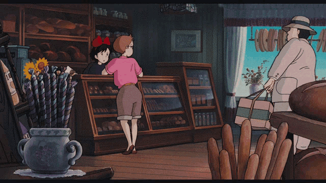 a woman in a pink shirt is standing in a bakery with a red bow on her head