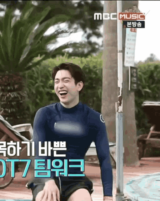 a man in a blue shirt is laughing in a mbc music video