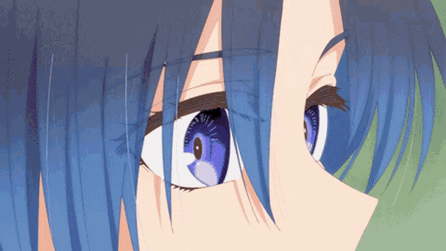 a close up of a person 's blue eyes with a green background