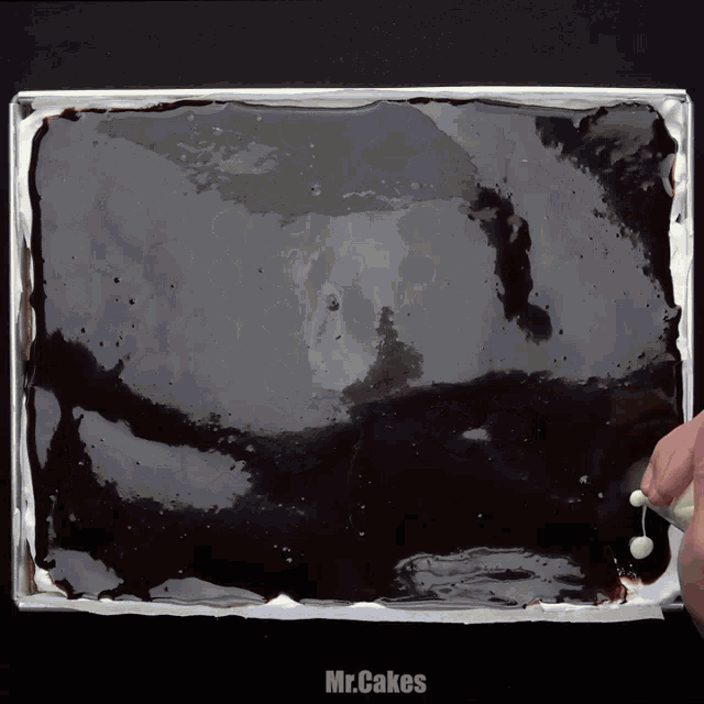 a tray of chocolate covered cake with mr.cakes written on the bottom right