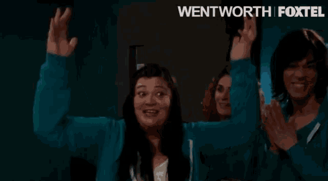 a woman with her arms outstretched and the words wentworth foxtel in the background