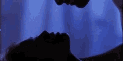 a man and a woman are kissing in the dark in a room .