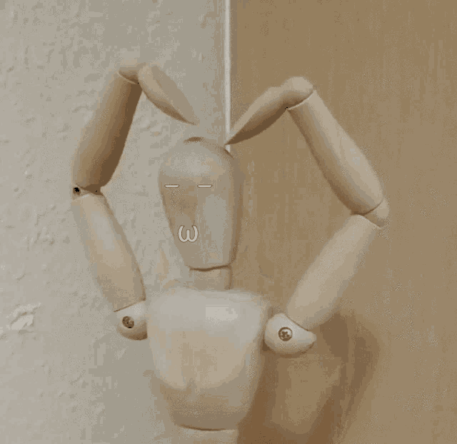 a wooden mannequin is making a heart shape with its arms