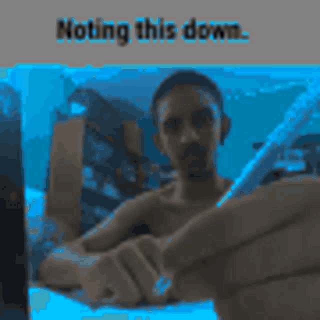 a man without a shirt is holding a cell phone in front of a blue background that says nothing this down