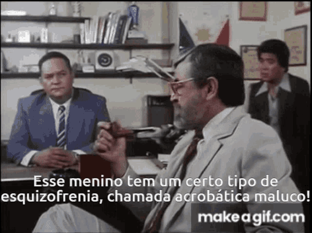 a man in a suit and tie is smoking a pipe and talking to another man