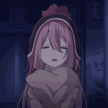 a girl with pink hair and a hat is wrapped in a blanket and making a sad face .