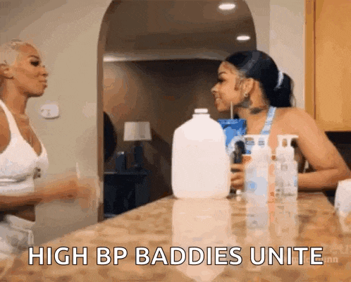 two women are standing next to each other on a counter and talking .