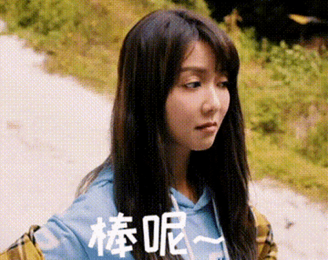 a woman with long hair is wearing a blue hoodie