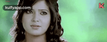 a close up of a woman 's face with a green background and a watermark .