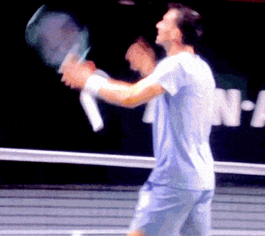a blurry picture of a man holding a tennis racket in front of a sign that says n-a