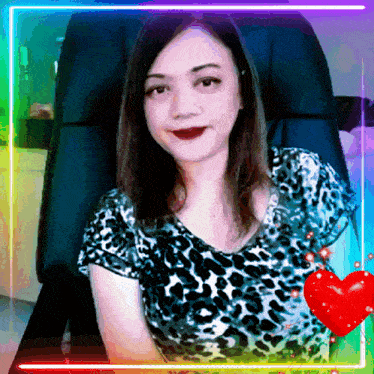 a woman in a leopard print shirt sits in a chair with a rainbow frame around her