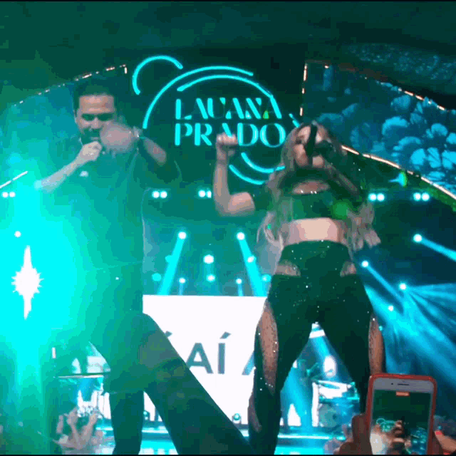 a man and a woman on a stage with a sign that says lalana prado