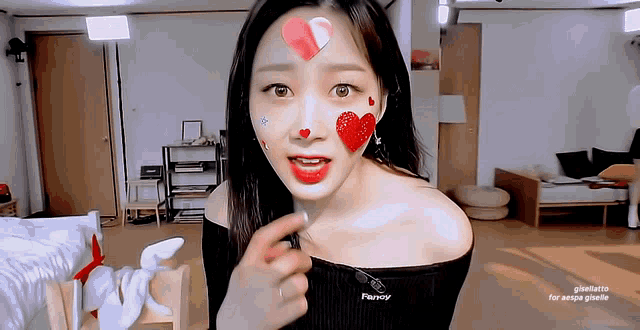 a woman with hearts painted on her face is wearing a black top with the word parroy on it