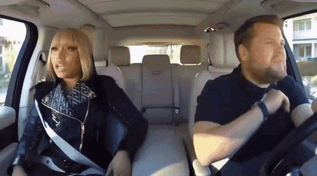 a man and a woman are sitting in a car talking